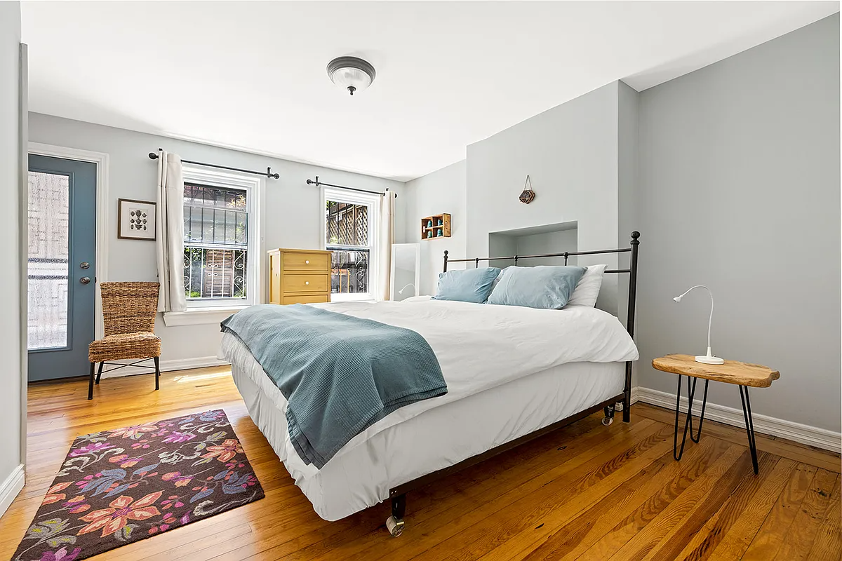 bedroom with wood floor, door to garden