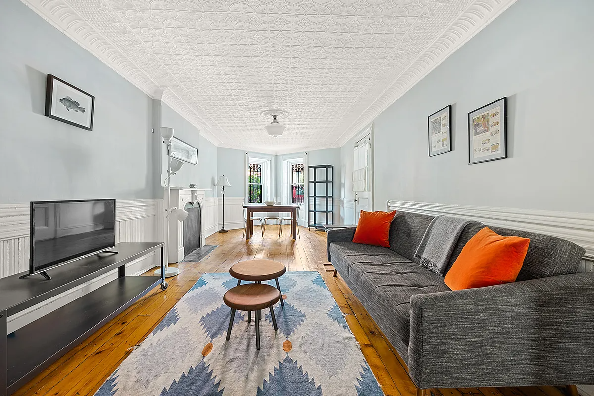living room with tin ceiling, wainscoting