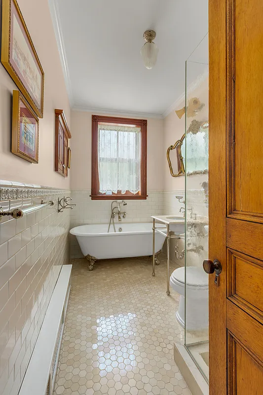 bathroom with claw foot tub, a shower and white subway tile with a border