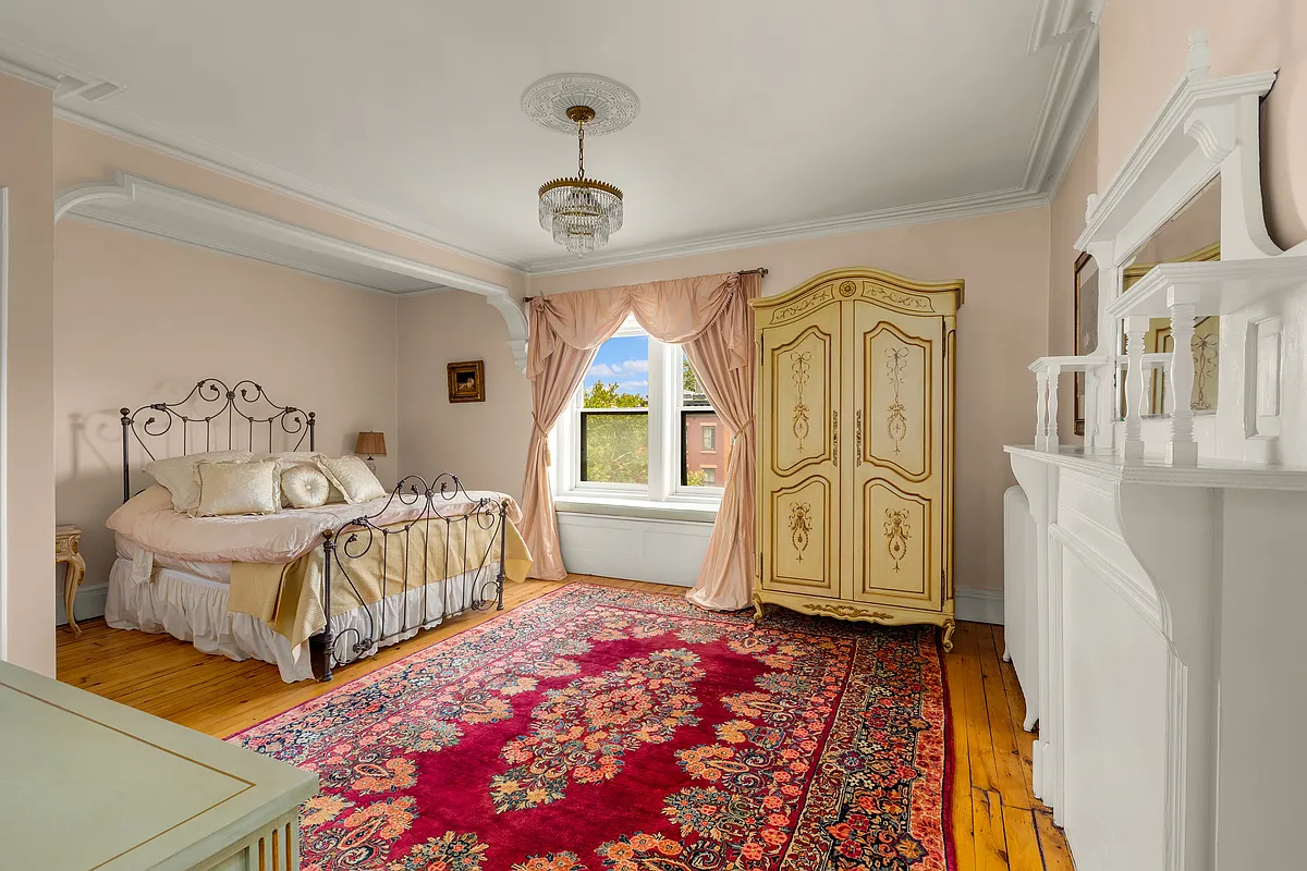 a bedroom with wood floor, a white painted mantel