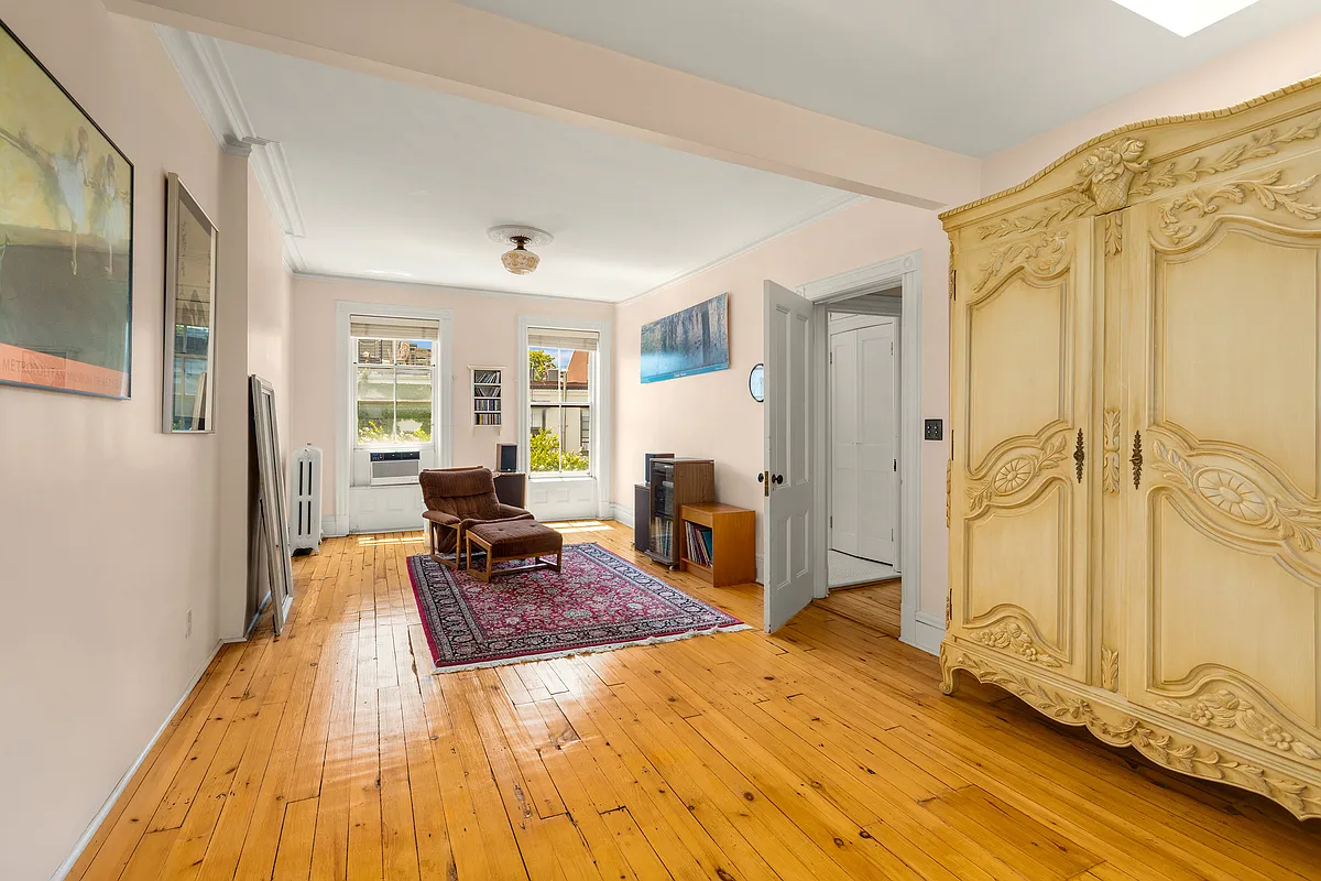 a bedroom with wood floor, skylights