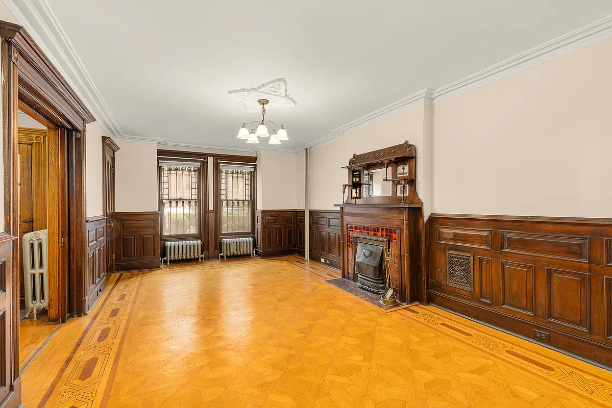 dining room on garden level with wainscoting, mantel and wood floor