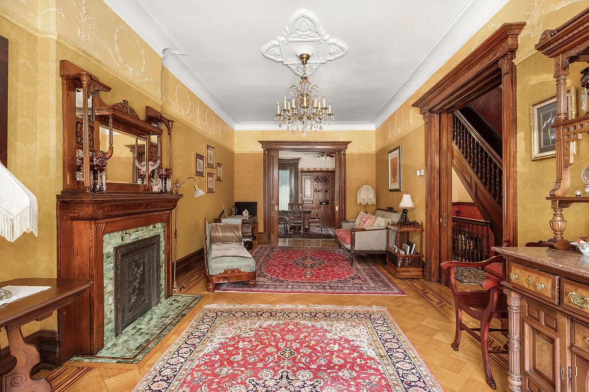 parlor with golden walls, plasterwork, wood floor and a wood mantel