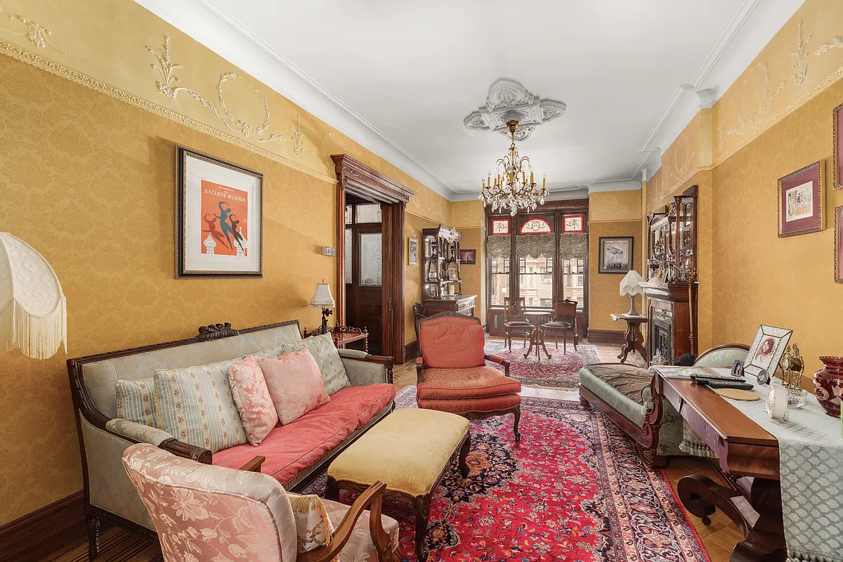 parlor with golden walls, plasterwork, wood floor and a wood mantel