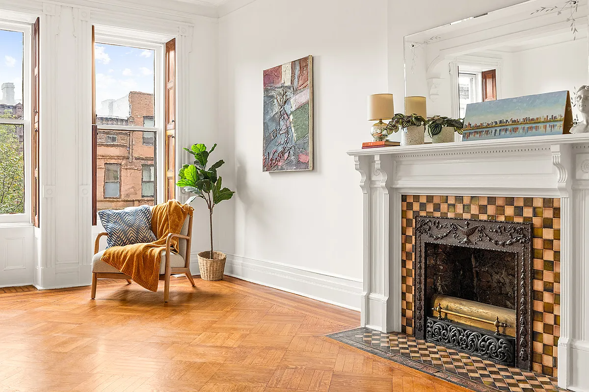 bedroom with interior shutters, white mantel with checkerboard fire surround,