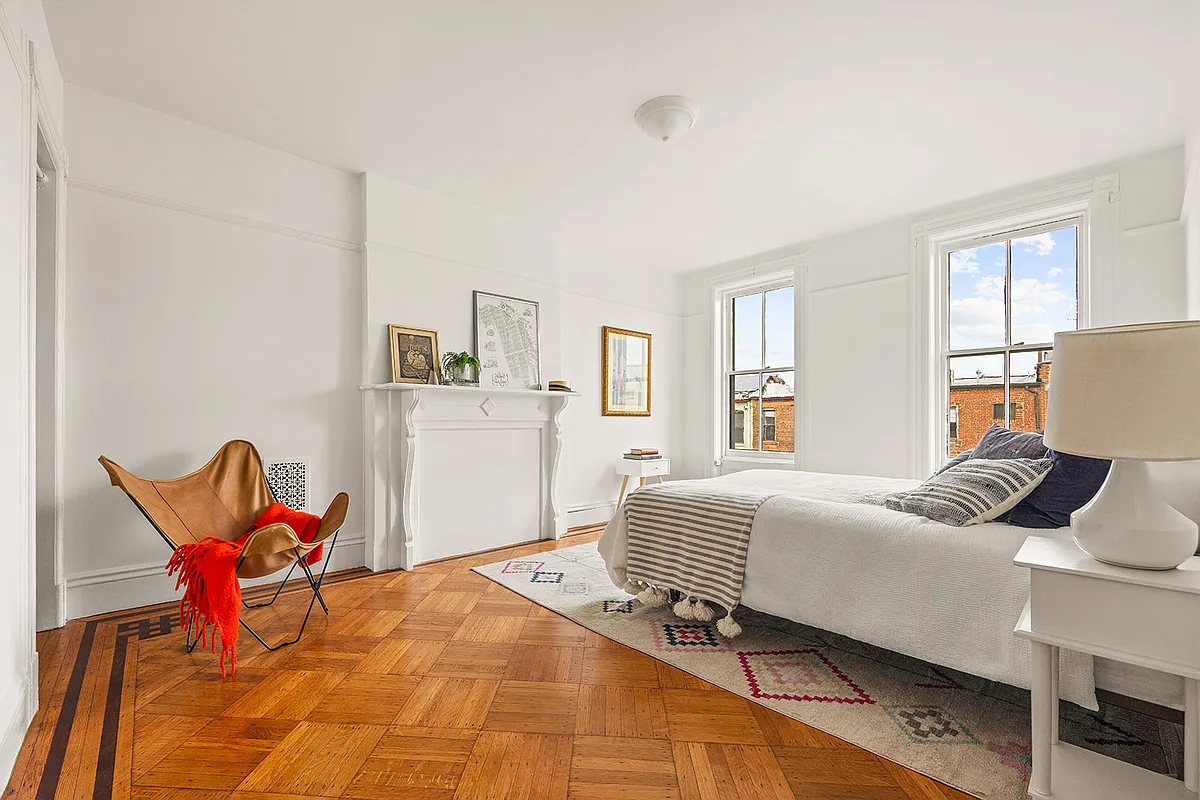 bedroom with white mantel, closed off firebox,