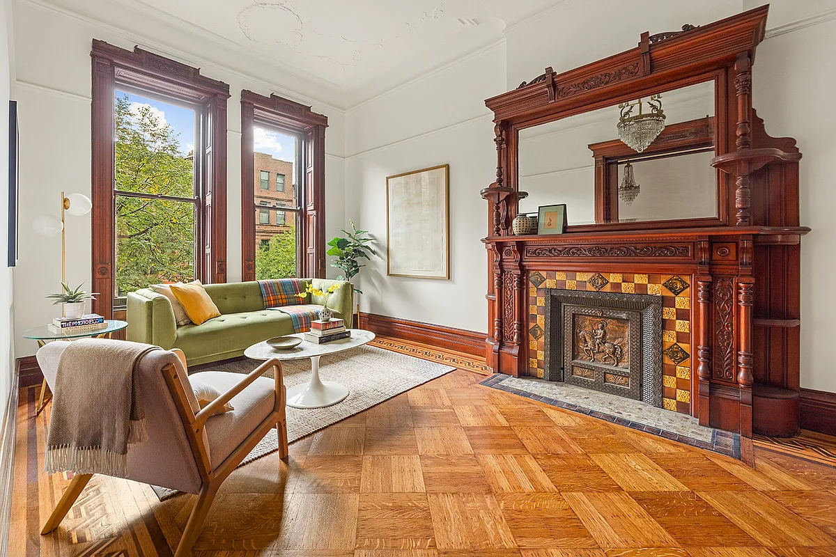parlor with wood mantel, wood floor and moldings