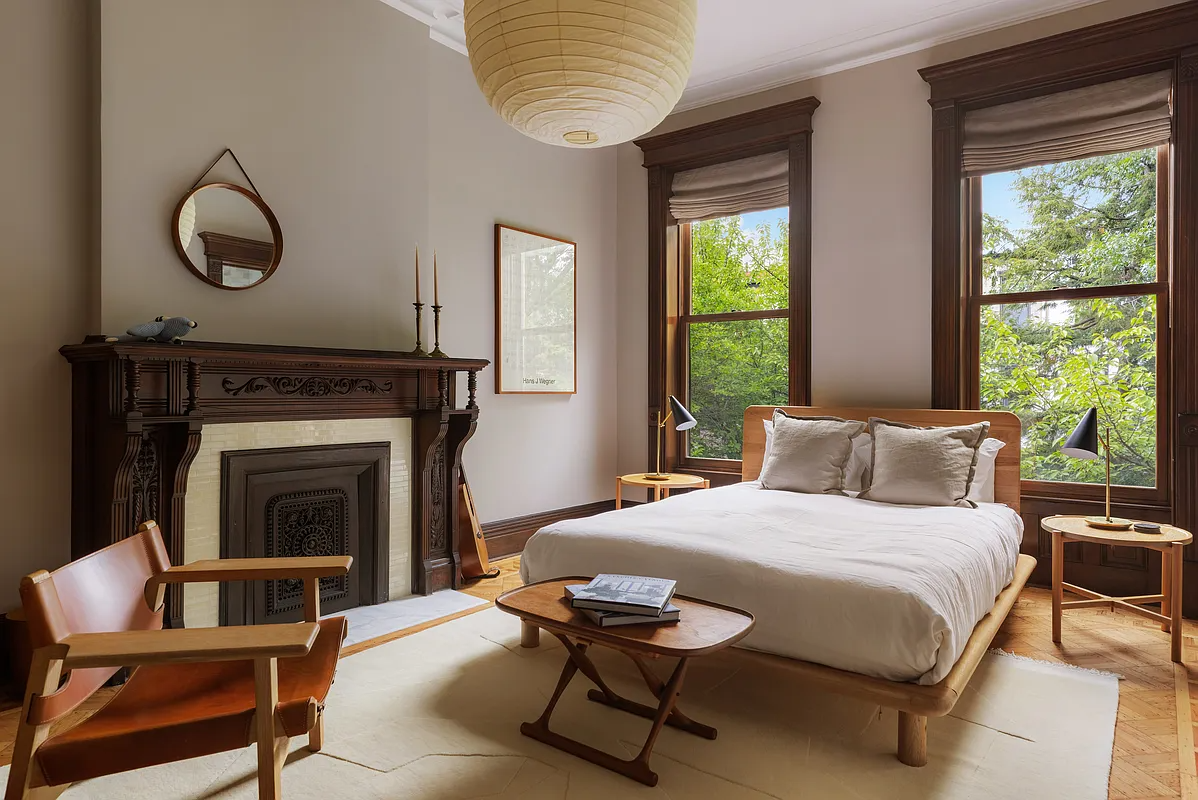 bedroom with wood mantel and wood floor