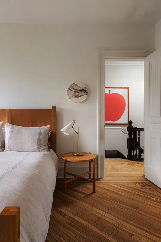 bedroom with wood floor and view into hall