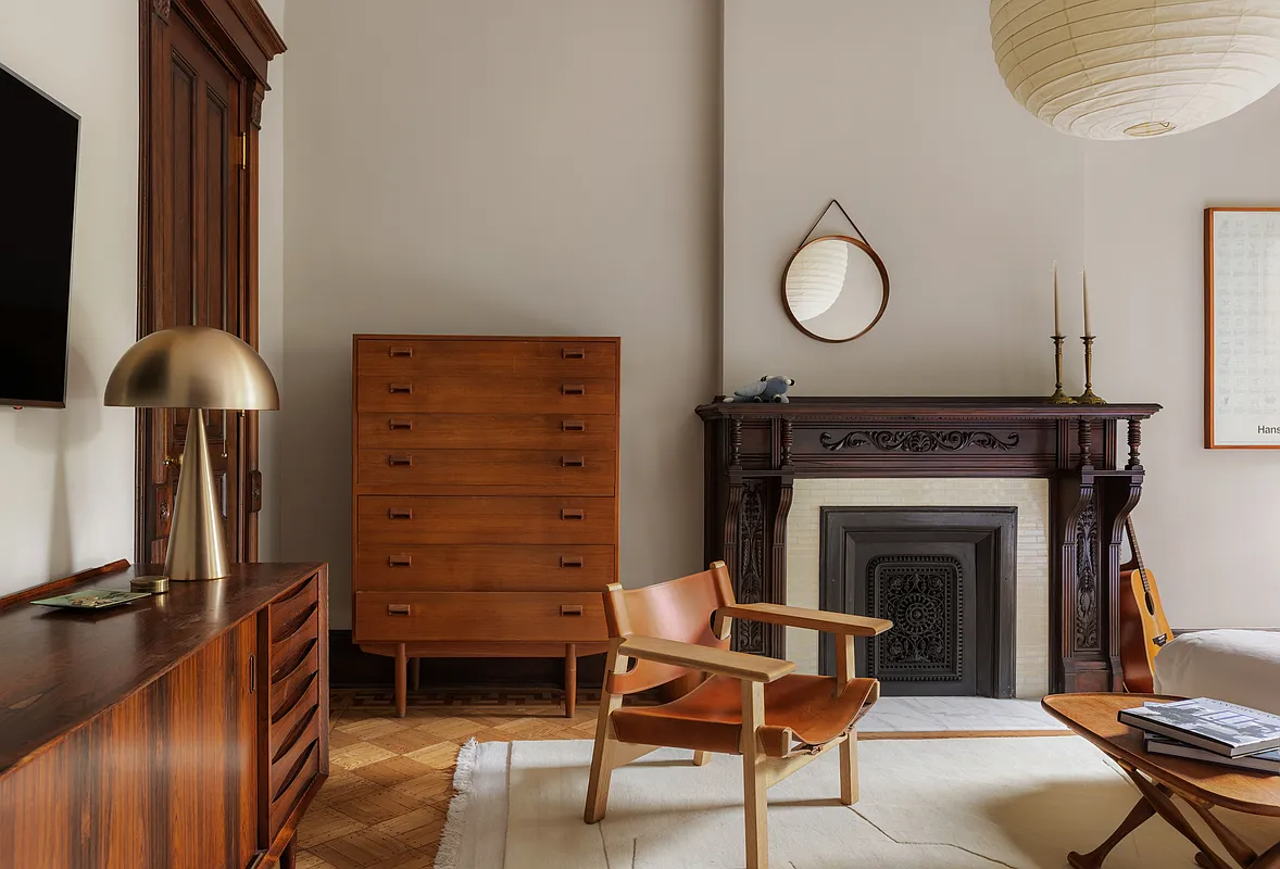 bedroom with wood mantel and neutral walls