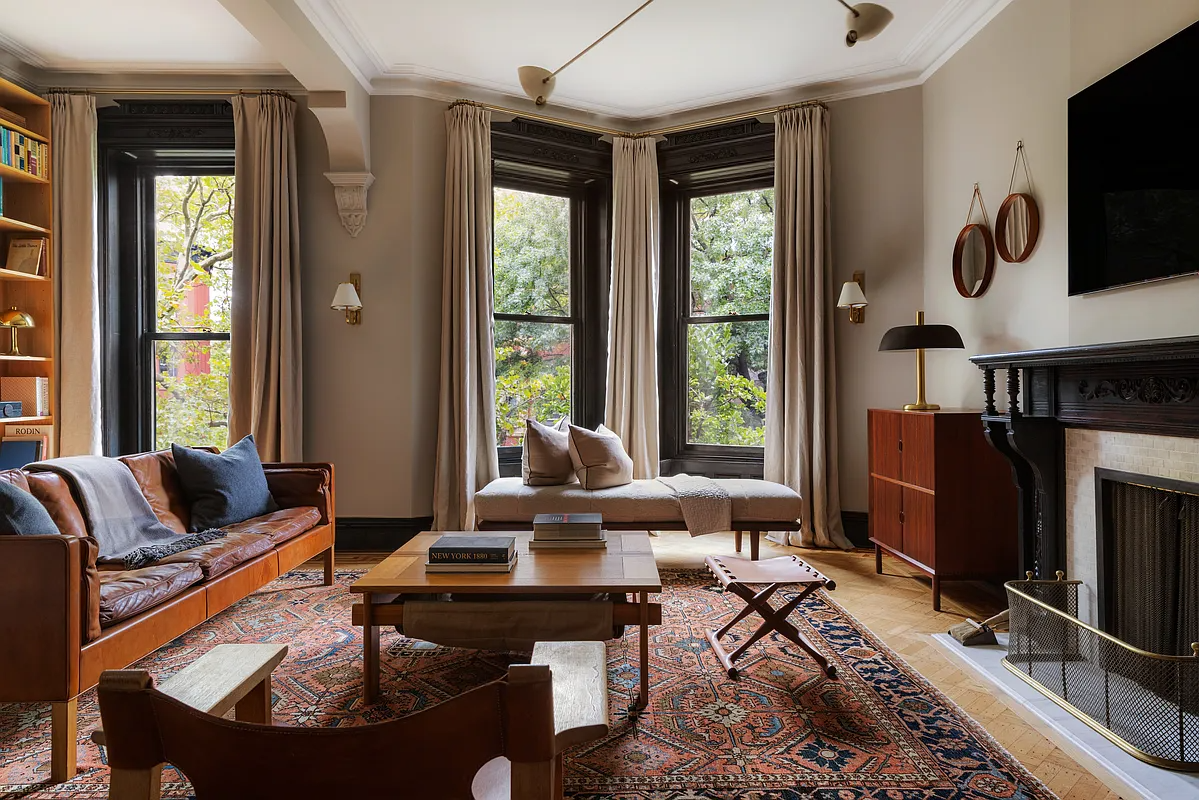 second floor bedroom set up as a den with a wood mantel, wall of bookshelves