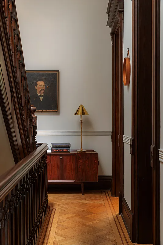 hallway with wood floor, moldings and stair