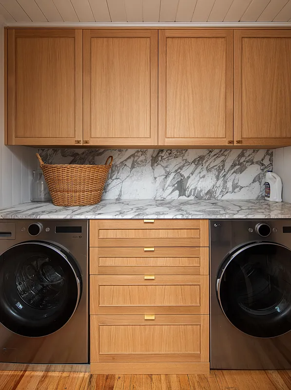 laundry room with full sized machine and cabinet storage