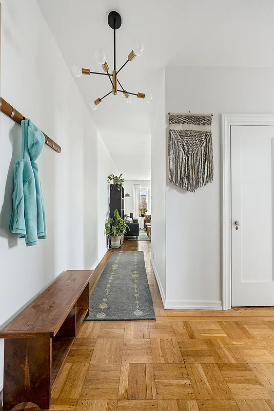 foyer with closets, wood floor, view down hallway to living room