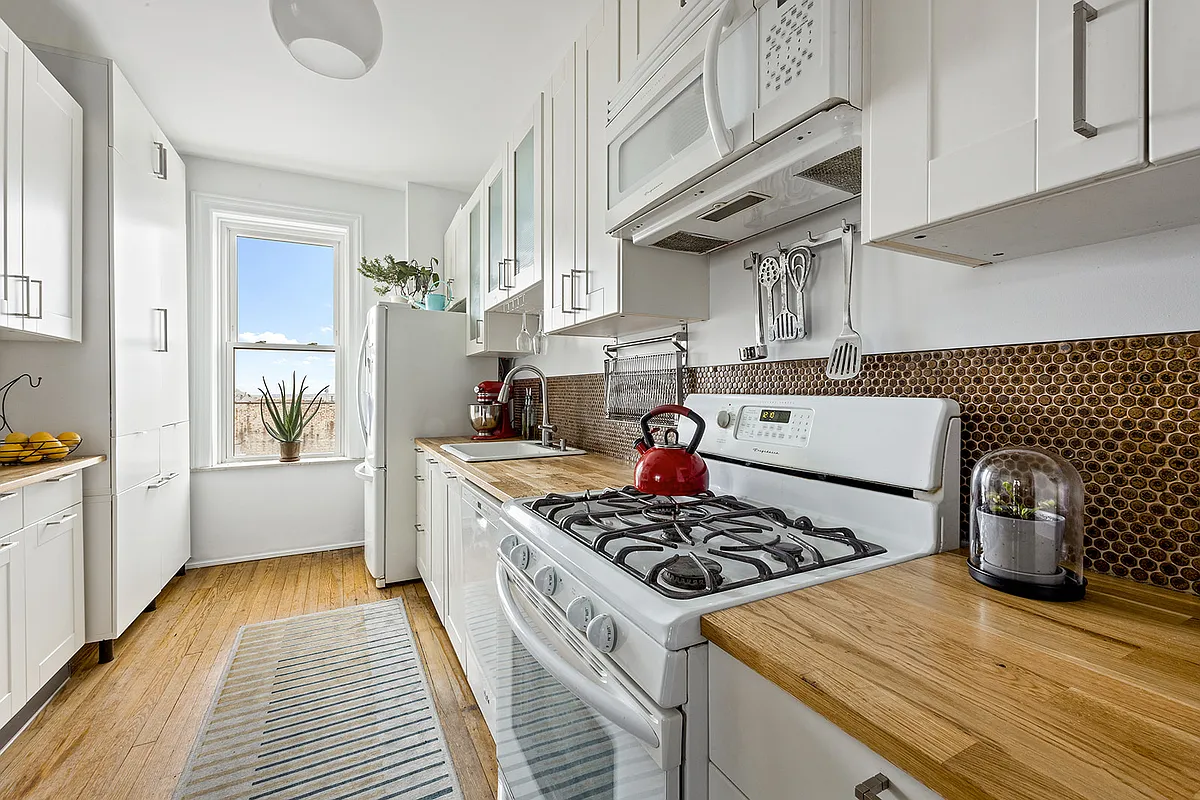 kitchen with white cabinets, white appliances, butcher block countertop