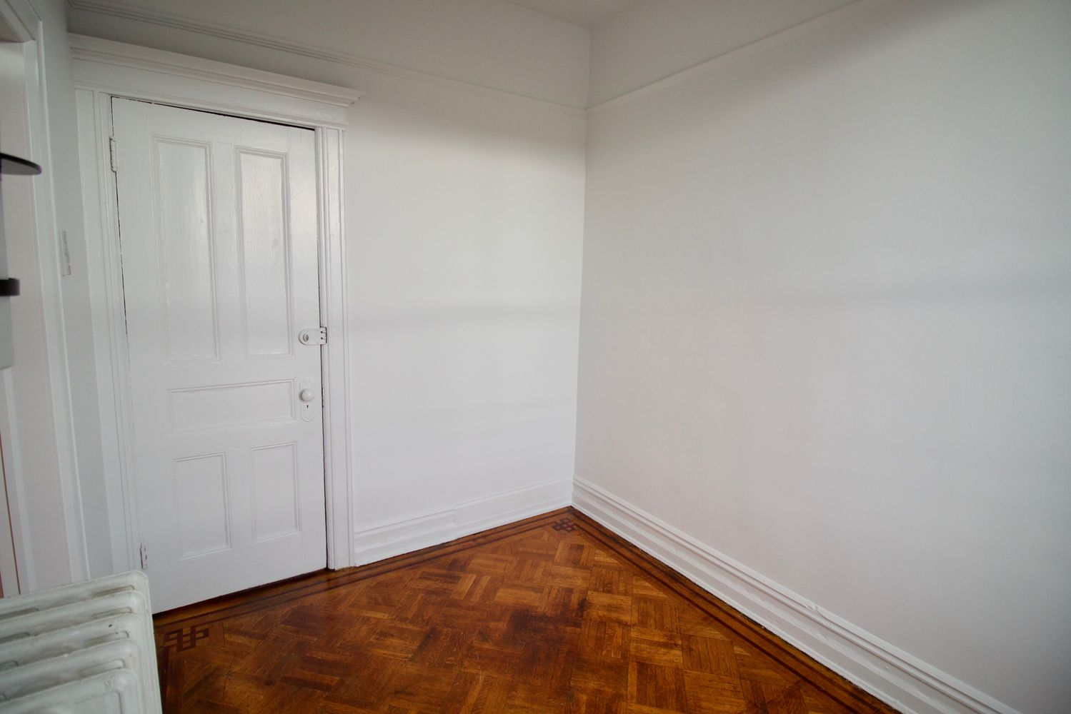 bedroom with white walls, wood floor