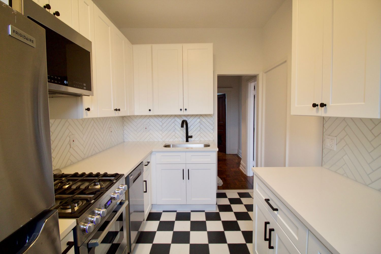kitchen with white cabinets, black and white floor tile