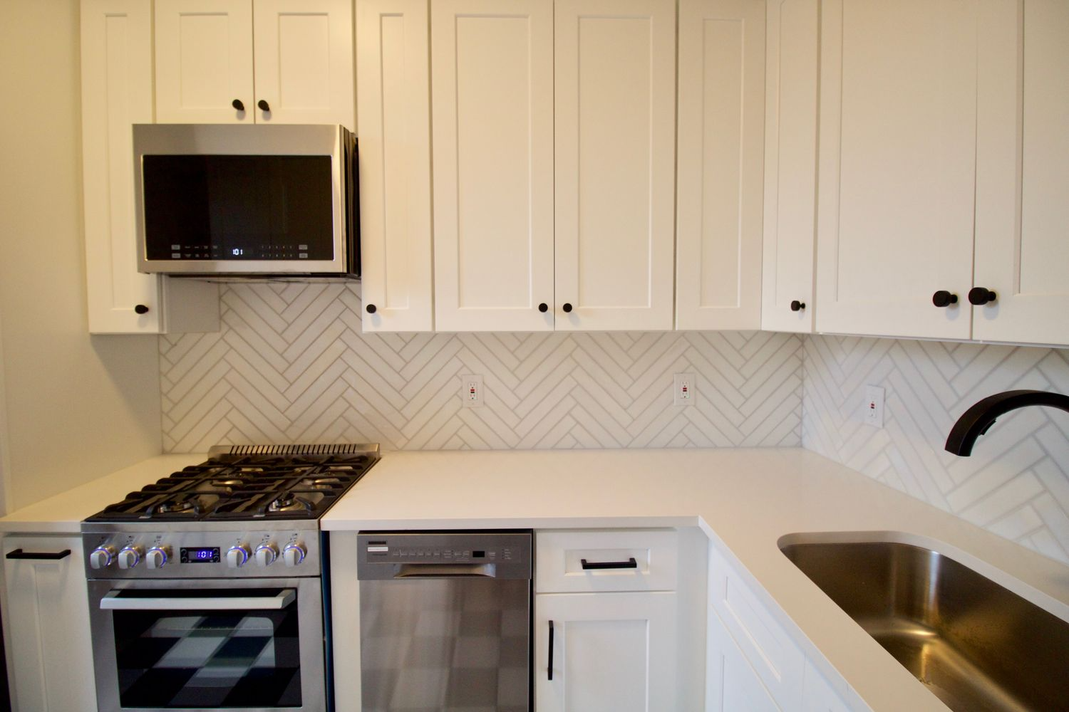 kitchen with white cabinets, black and white floor tile
