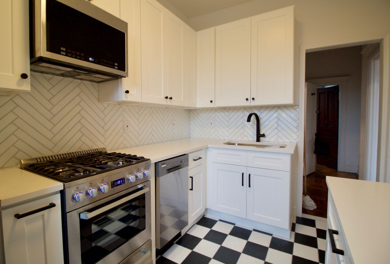 kitchen with white cabinets, black and white floor tile