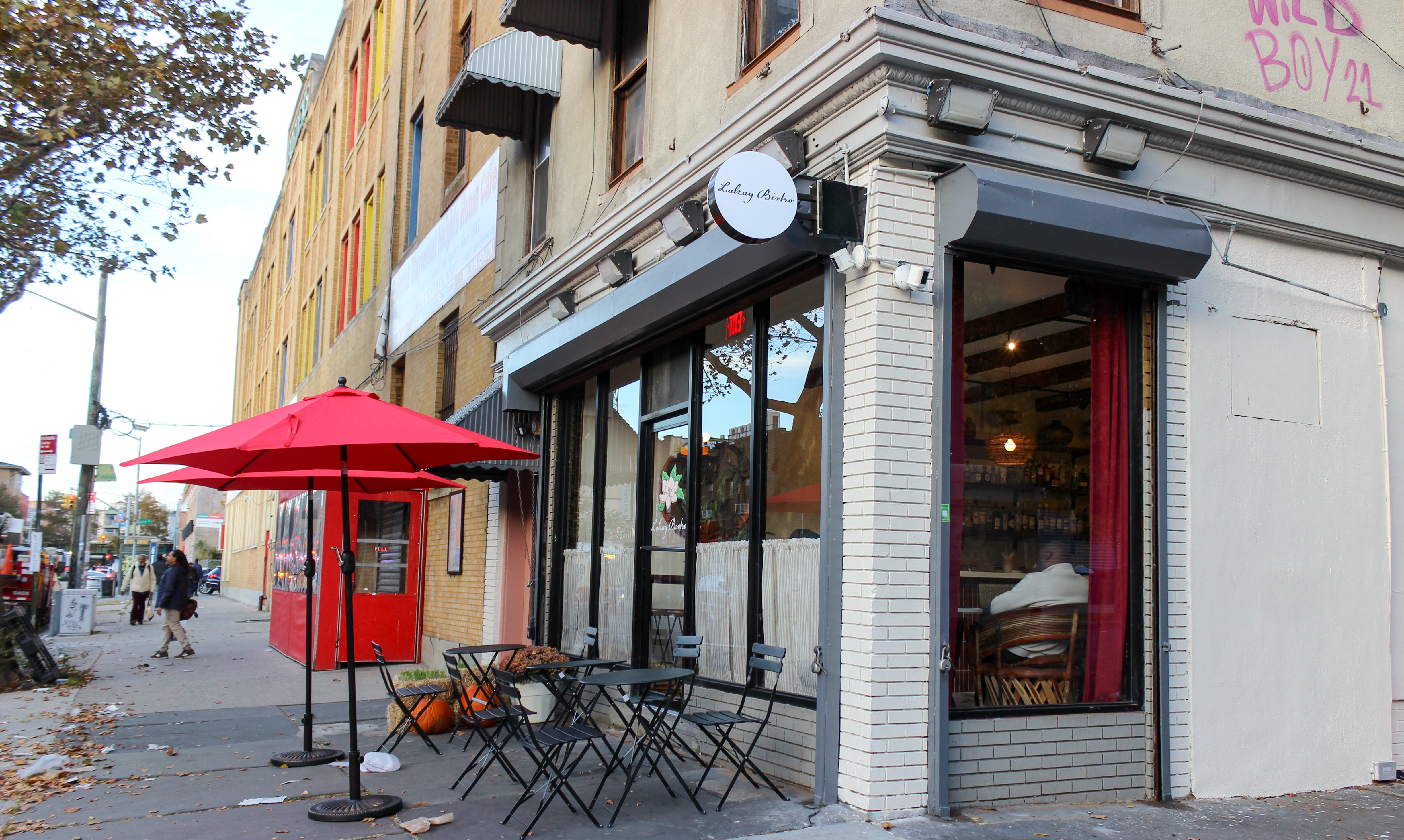 tables, chairs and red umbrellas outside a restaurant