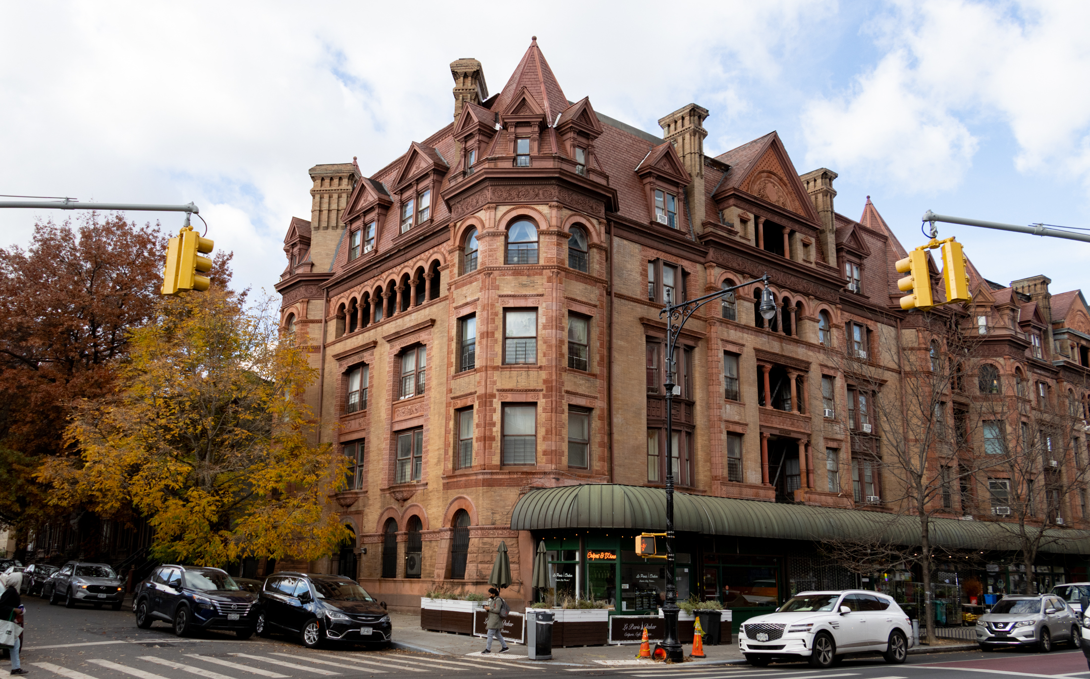 brick and brownstone apartment building with towers, dormers, and elaborate ornamentation