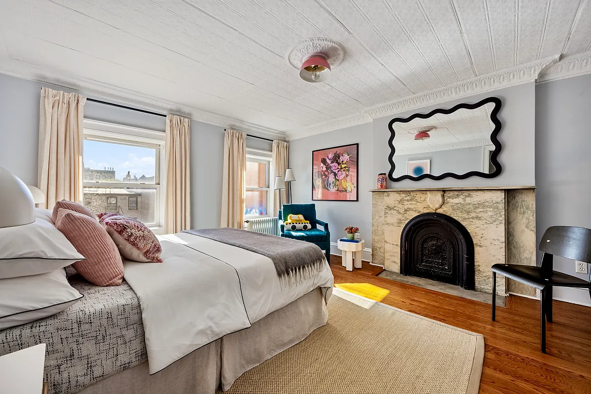 bedroom with tin ceiling, marble mantel