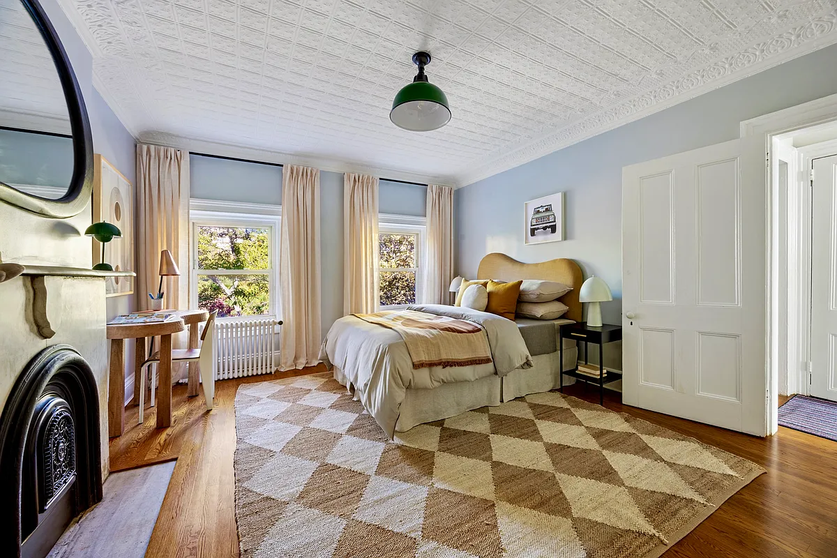 bedroom with tin ceiling, marble mantel