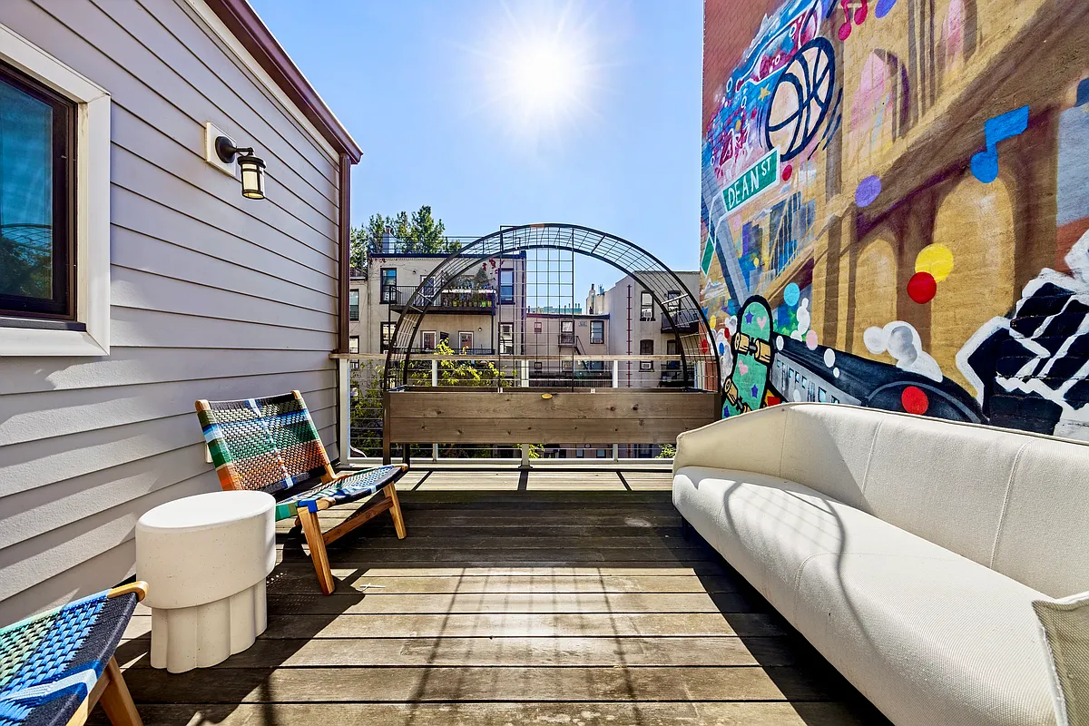 terrace with room for seating and planters and one wall painted with a mural