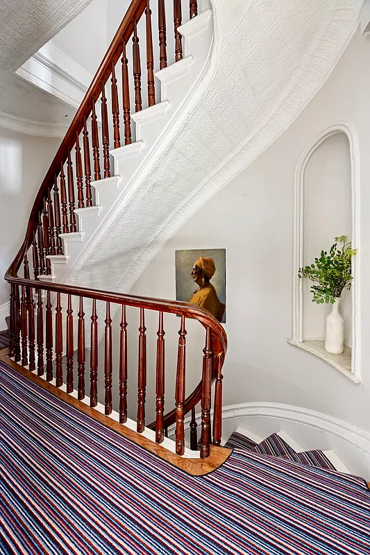 curved staircase with a stair niche