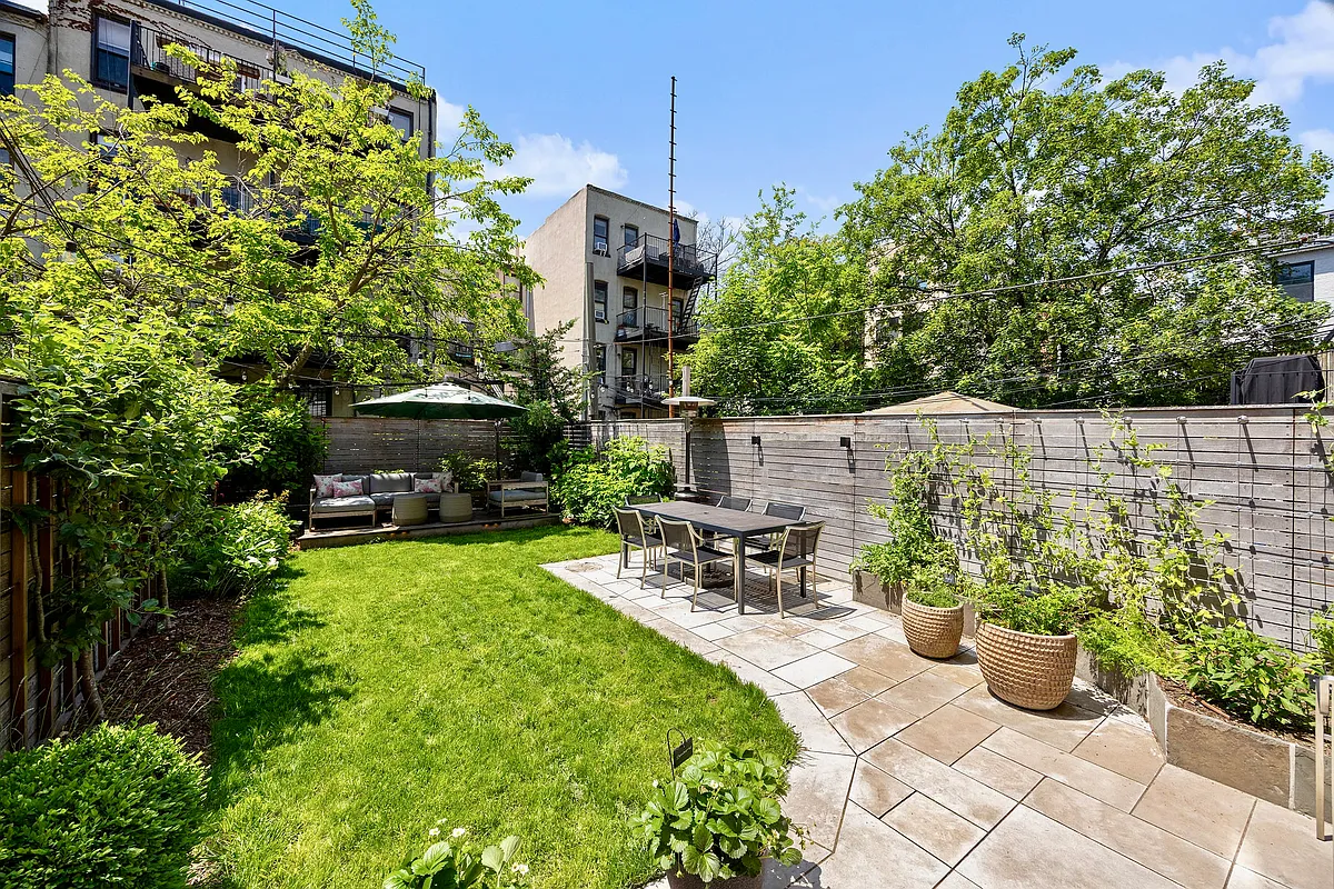 rear yard with stone patio and a small lawn