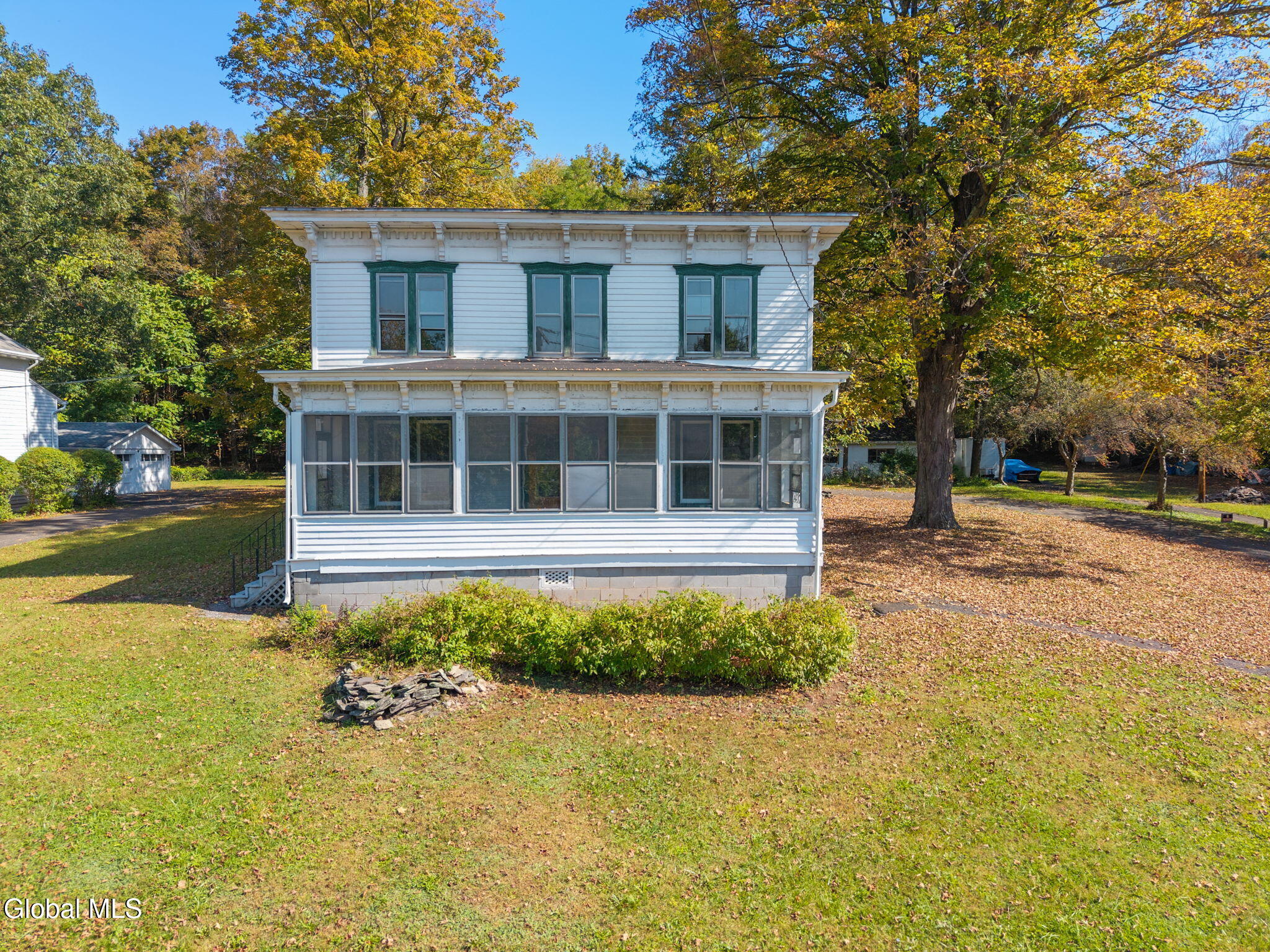 rectory with bracketed cornice and a screened in front porch
