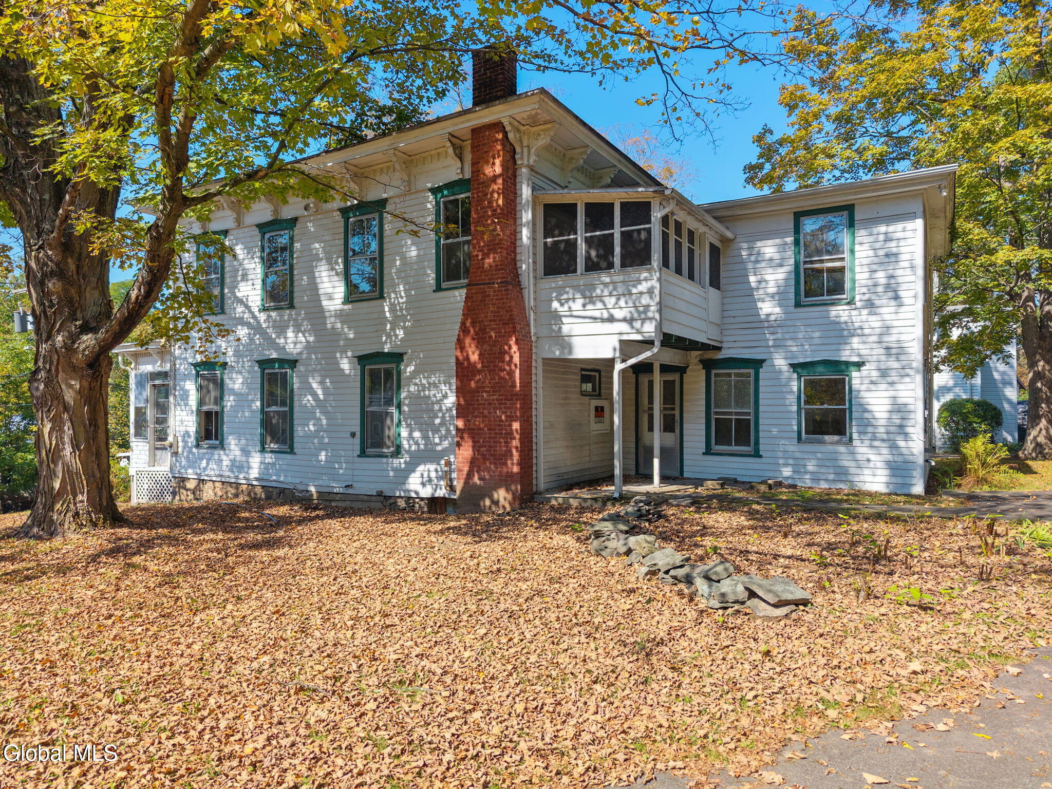 side facade of the rectory showing brick chimney and a rear porch