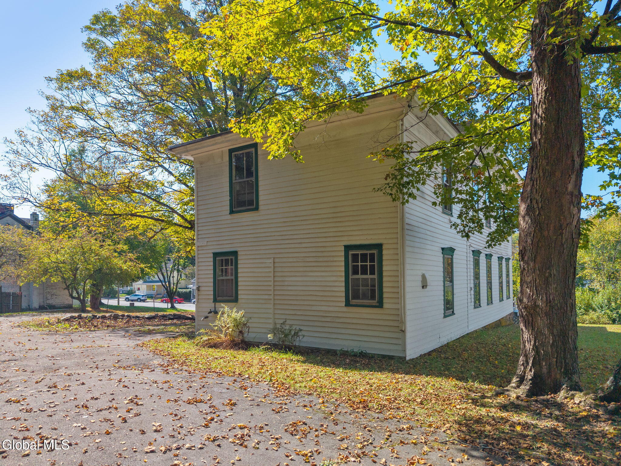 rear facade of white clapboard rectory with green trim
