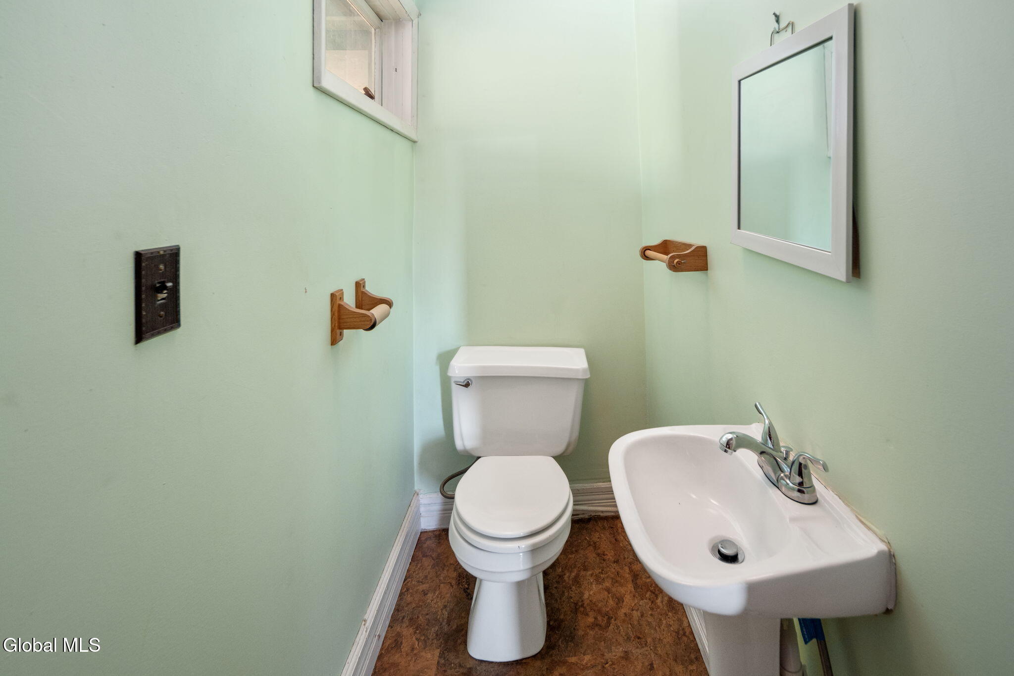 half bath with white fixtures and green walls