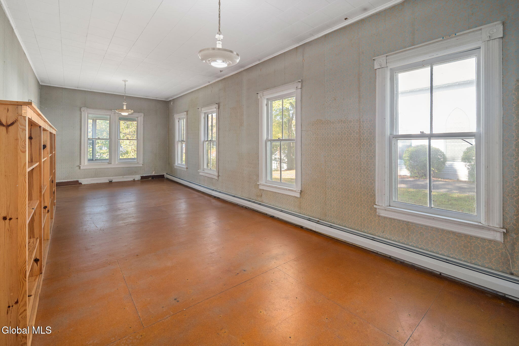 living room in the rectory with baseboard heating, wallpaper