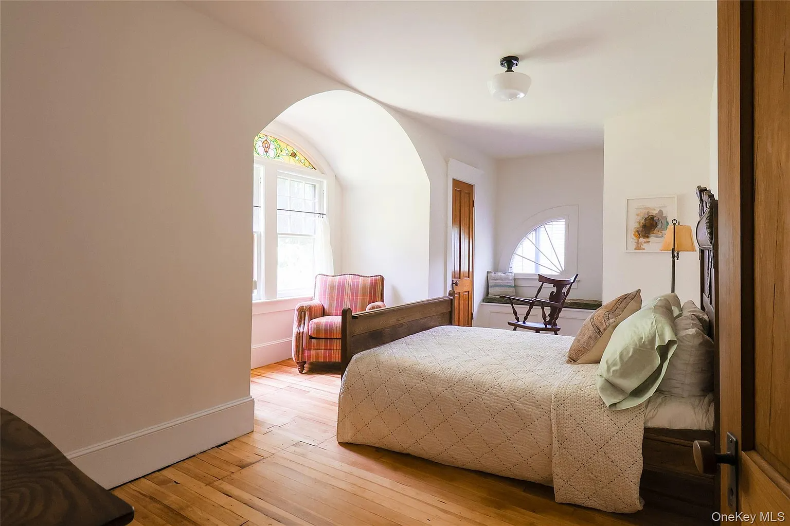bedroom with arched niche with stained glass window
