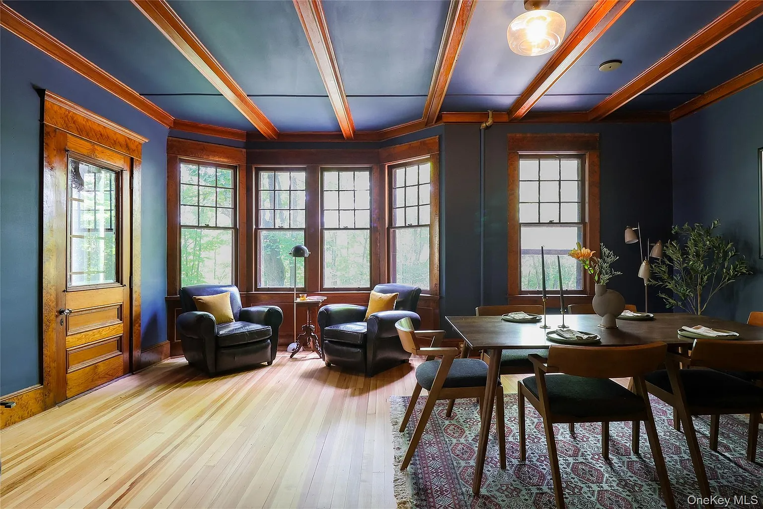 dining room with dark blue walls, beamed ceiling