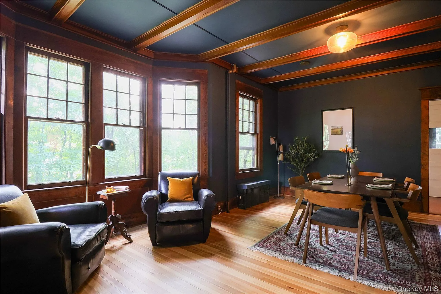 dining room with dark blue walls, beamed ceiling