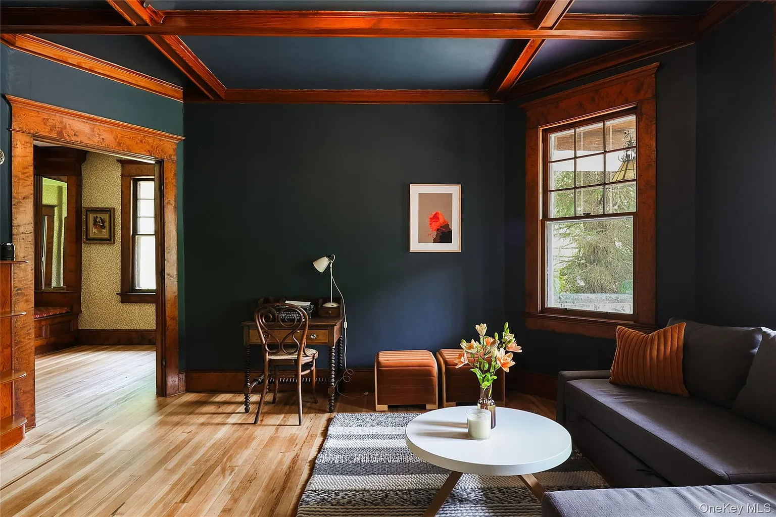 parlor with dark blue walls, wood beams and trim