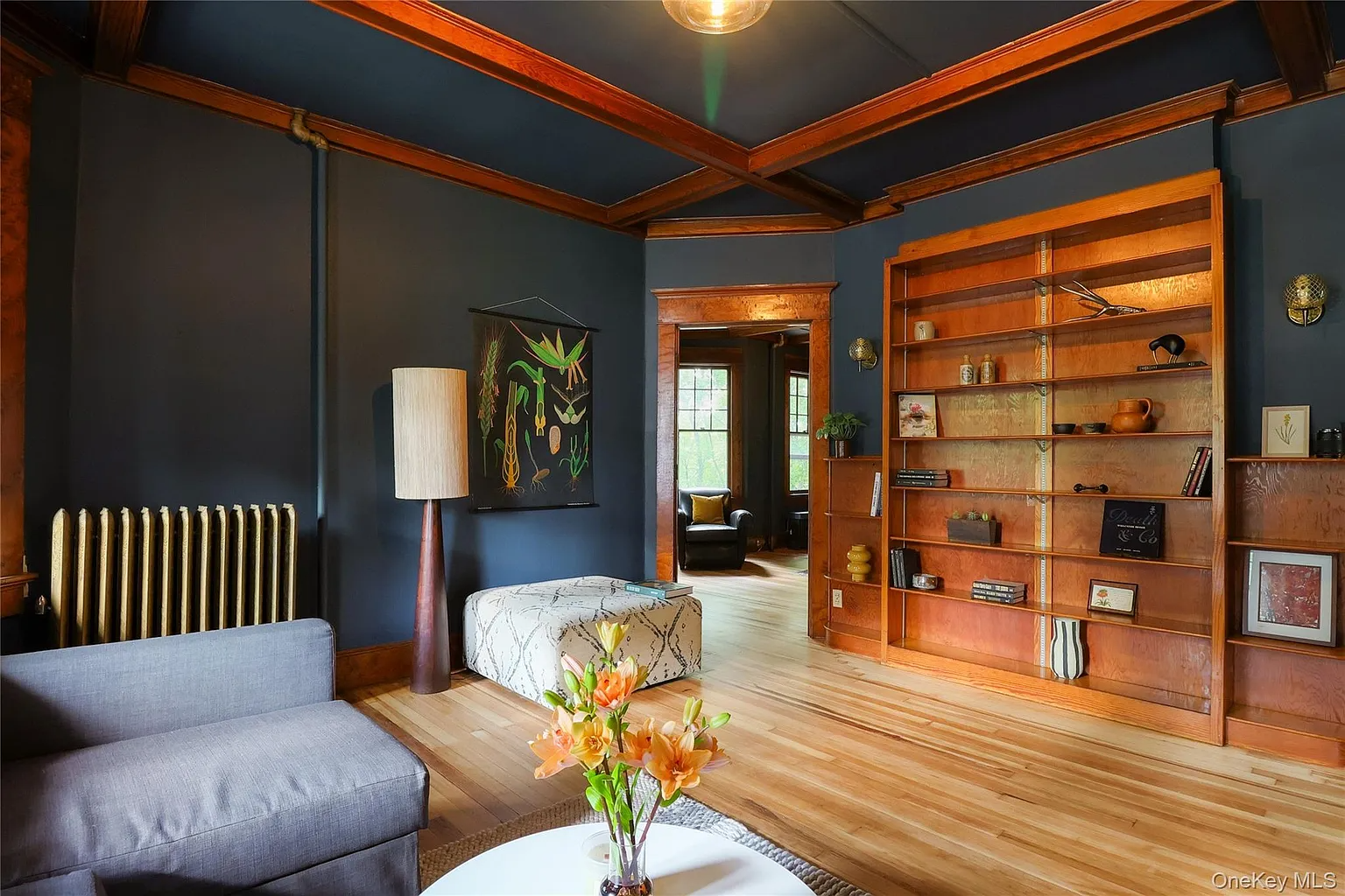 parlor with dark blue walls, wood beams and trim