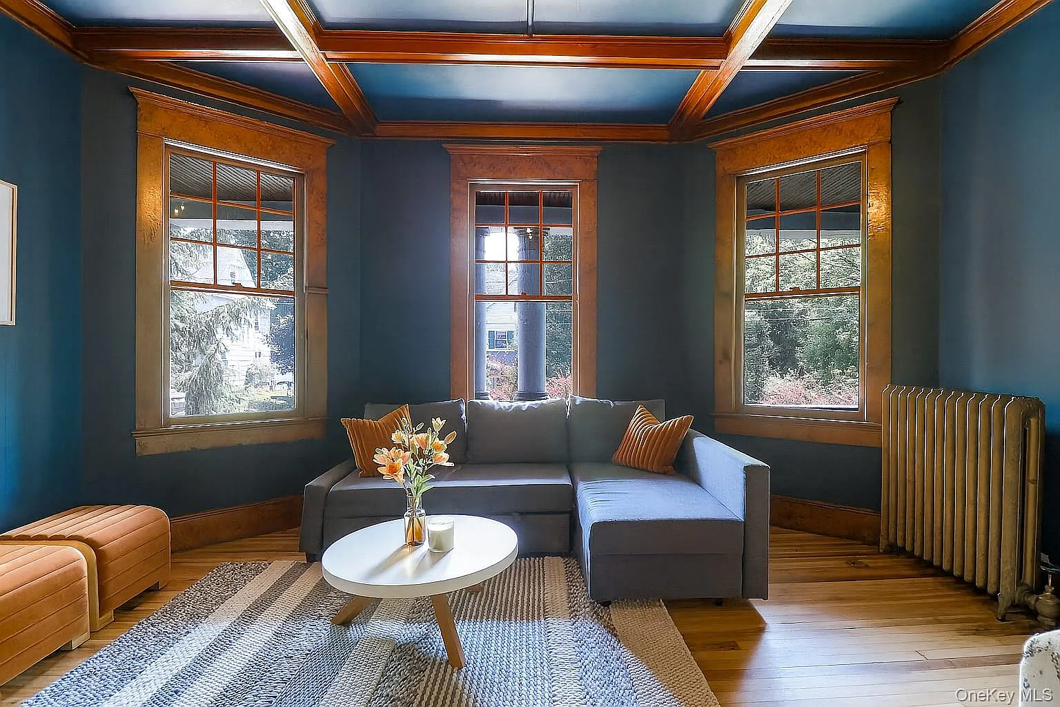parlor with dark blue walls, wood beams and trim