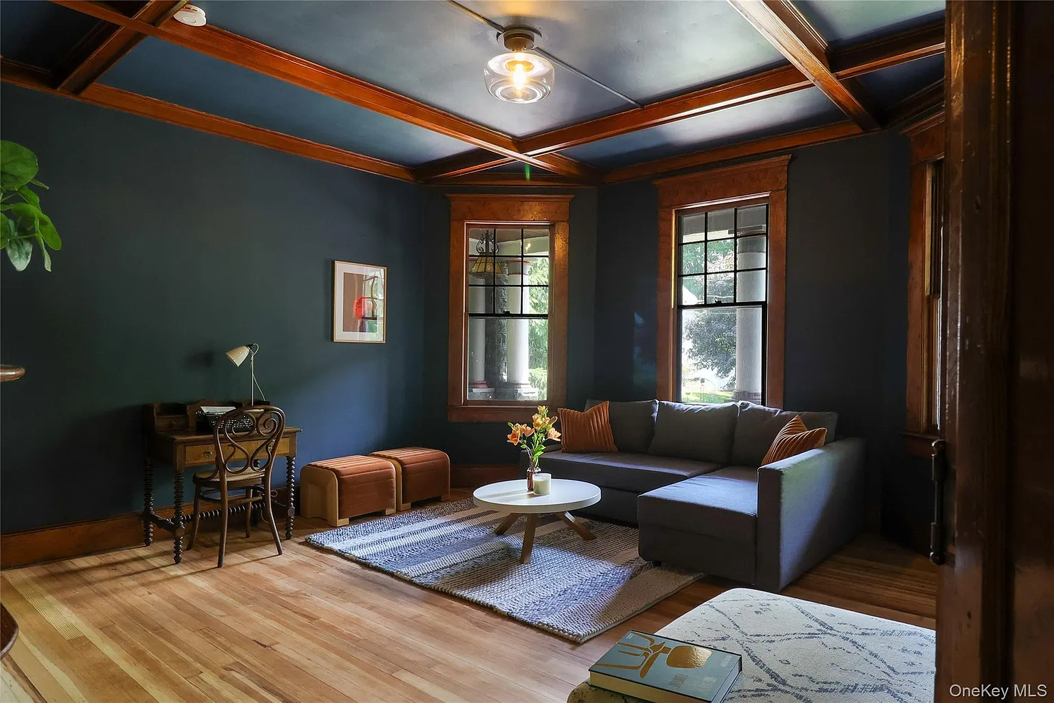 parlor with dark blue walls, wood beams and trim