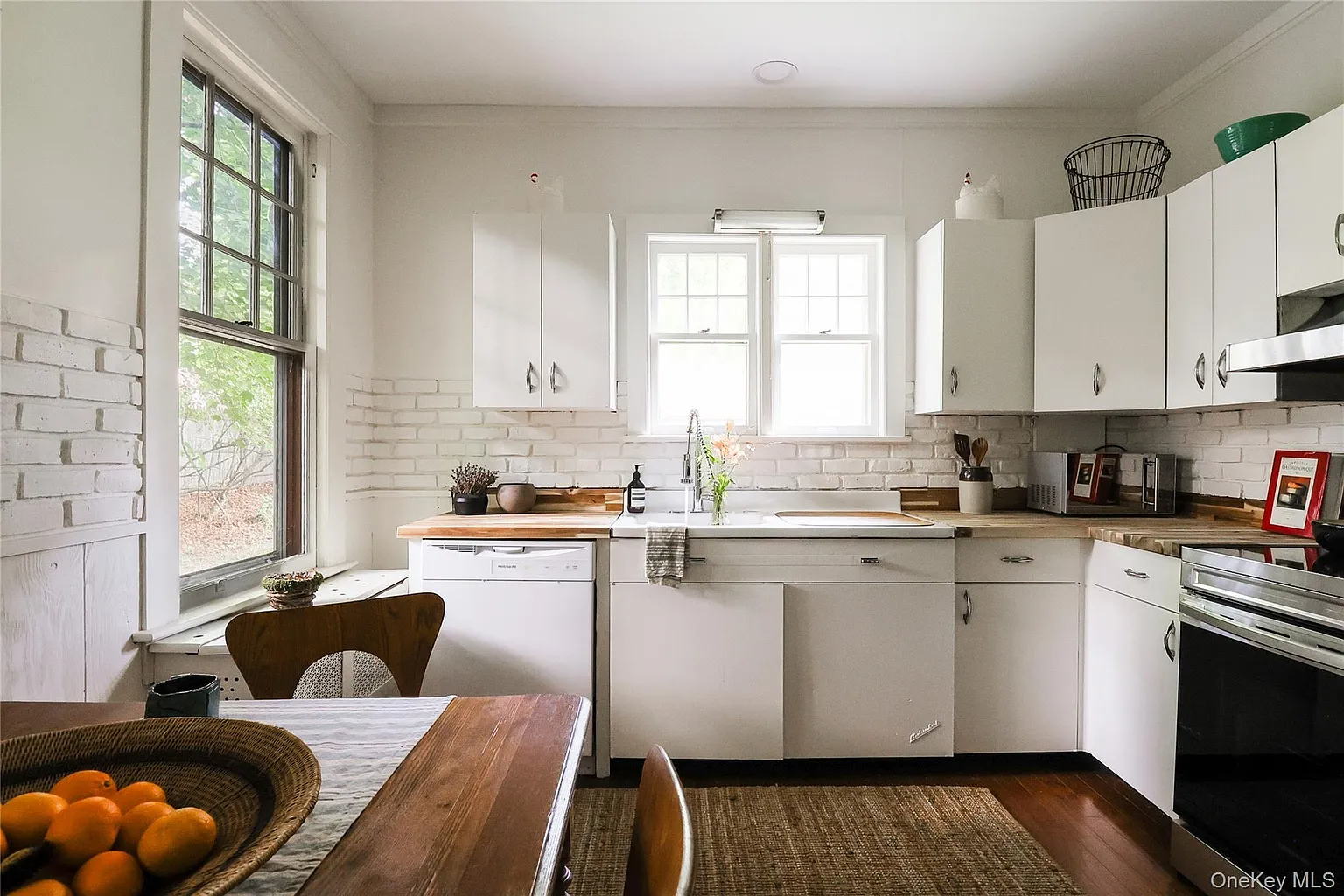 kitchen with vintage white metal cabinets, exposed brick painted white