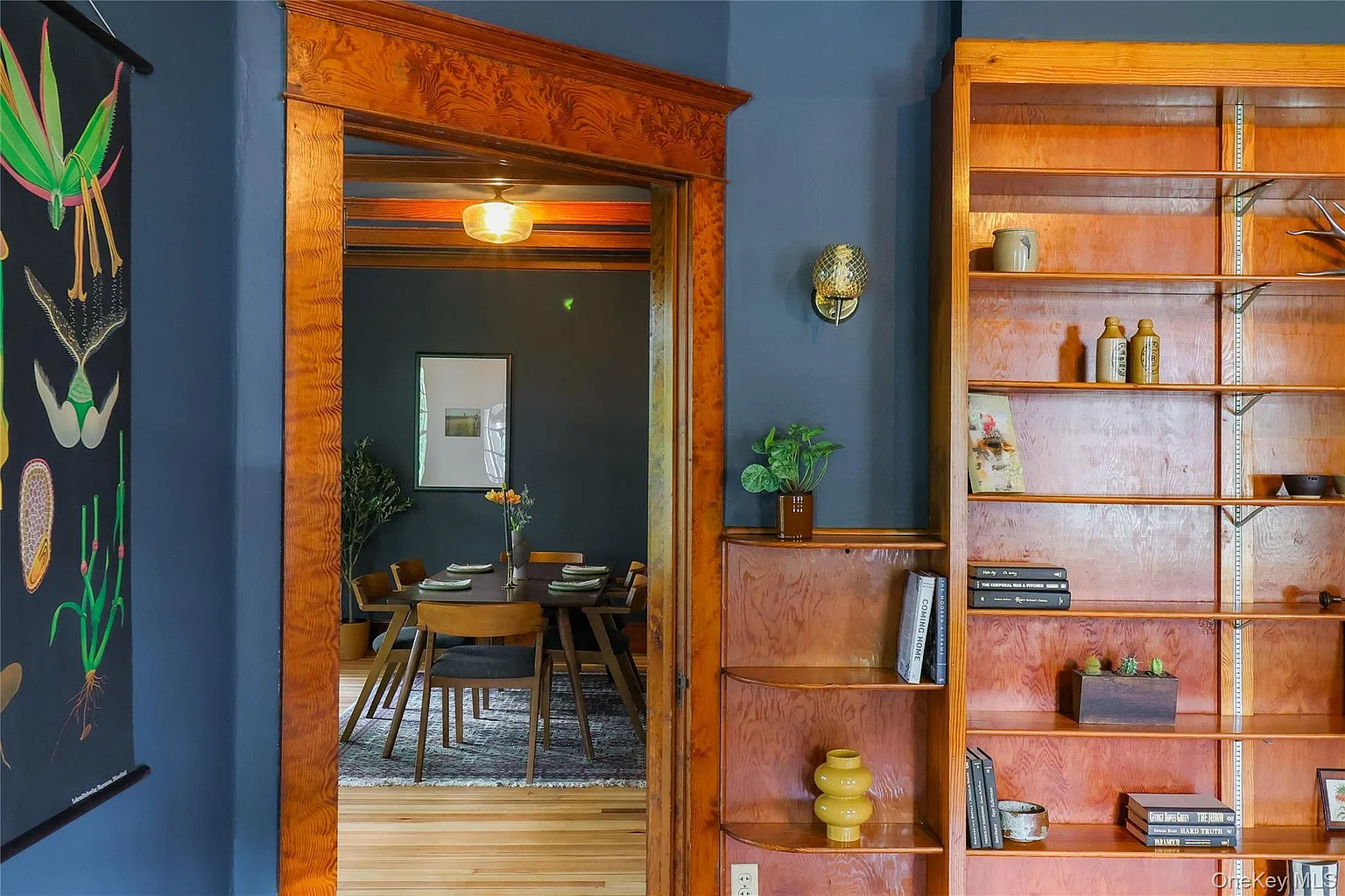 parlor with dark blue walls and wood bookshelves