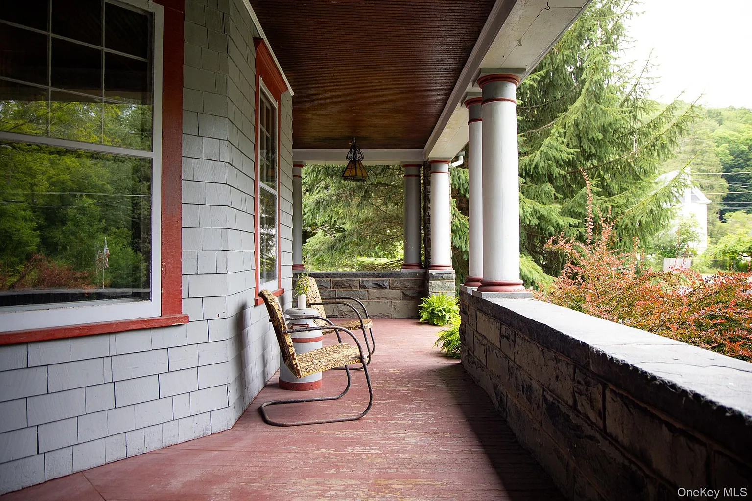 front porch with red painted floor, room for seating, and columns