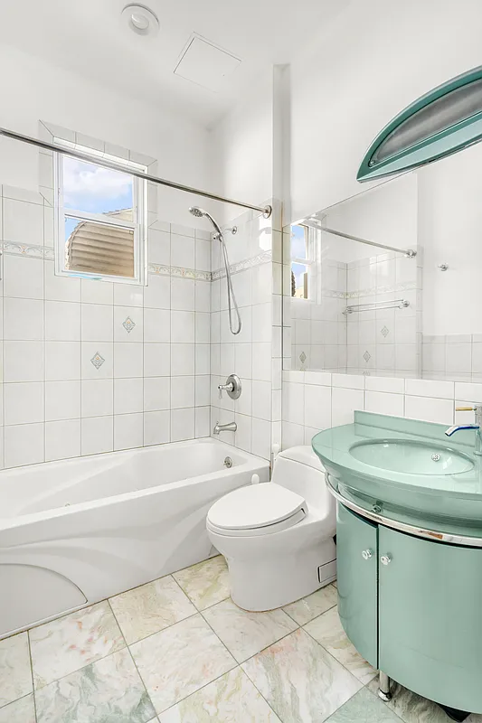 bathroom with green curved vanity, white tub