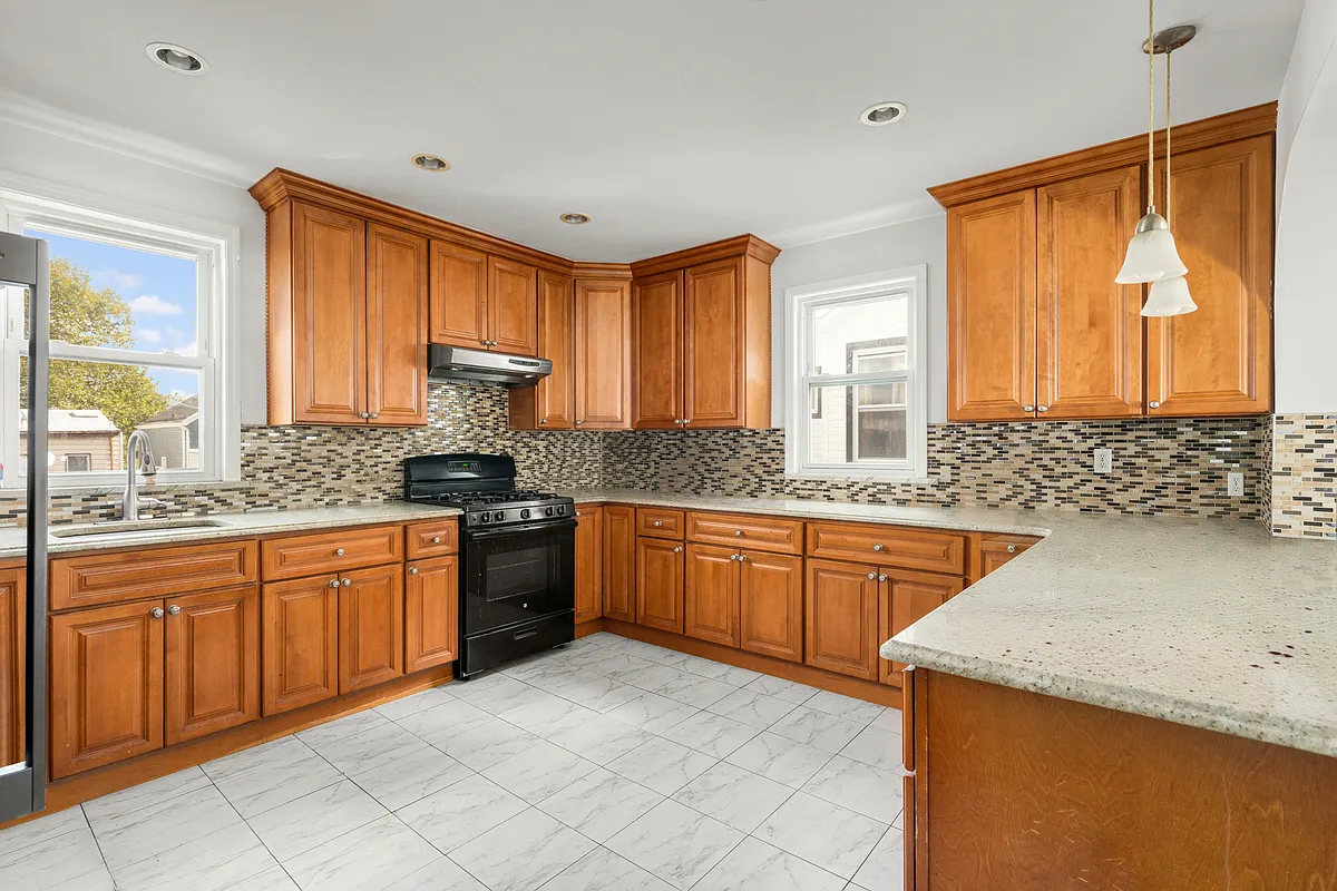 kitchen with brown tile backsplash, brown cabinets