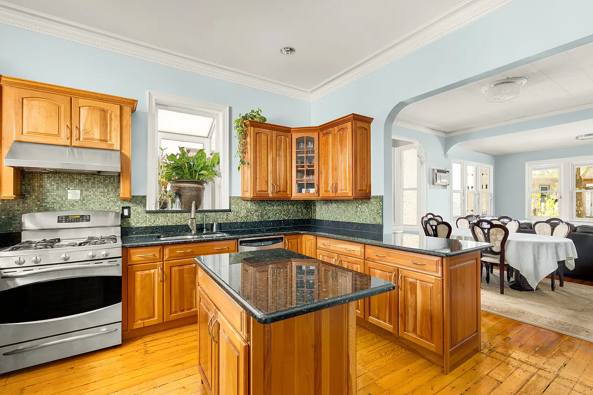 kitchen with arched doorway to living room, wood cabinets