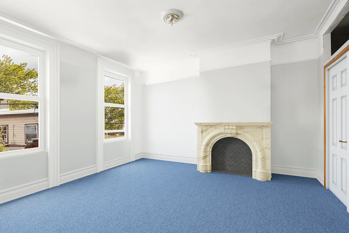 bedroom with blue carpet, marble mantel