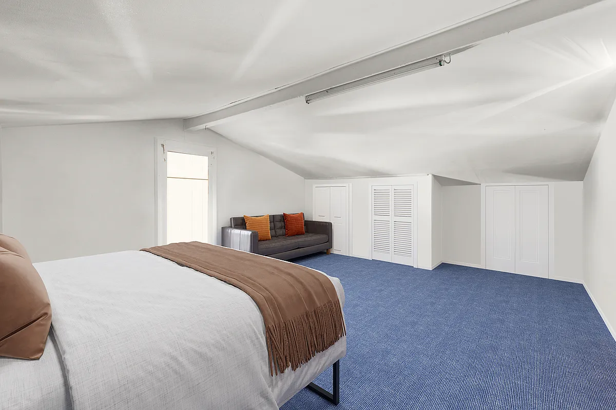 attic bedroom with sloped ceiling, blue carpet